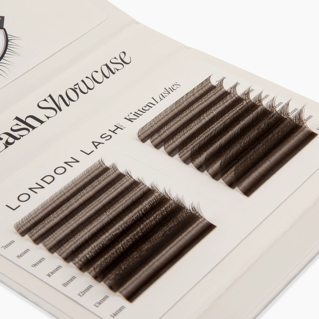 Top-angled view of a beige lash palette containing two columns of brown Kitten Lash strips in lengths from 7mm to 14mm.